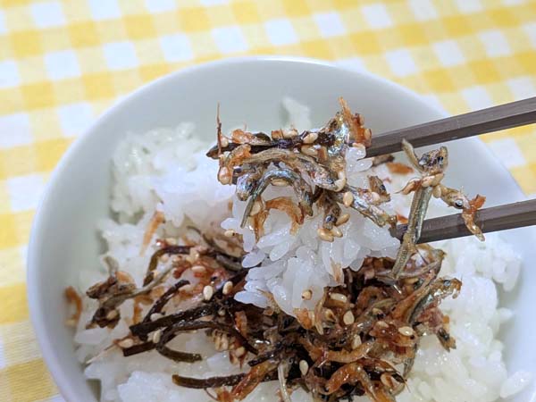 ひとまぜ御膳をのせたご飯を箸で持ち上げたところ